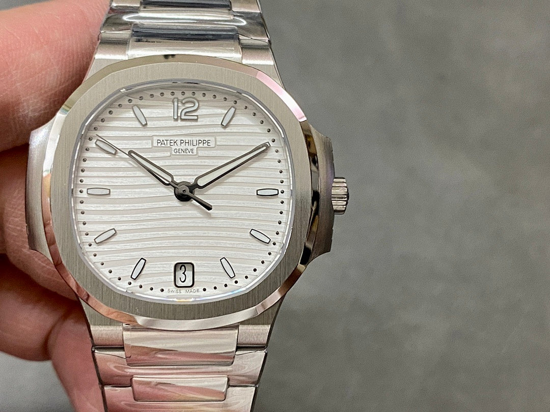 Wristwatch front view with silver dial, baton markers, date window at 3, steel bracelet