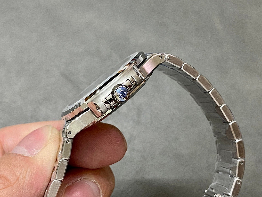 Patek Philippe wristwatch case with crown and blue gem set on bezel.