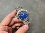 Patek Philippe wristwatch with blue dial, silver bezel, and metal bracelet.