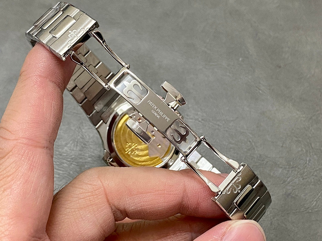 Patek Philippe wristwatch open caseback view with gold-toned center and metal bracelet