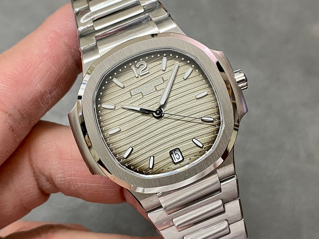 Patek Philippe wristwatch close-up with silver textured dial, baton hands, date at 3 o'clock