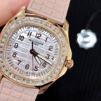 Patek Philippe watch close-up with pink strap, white dial, and diamond-set bezel