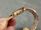 Gold-tone wristwatch clasp and crown side view, metal bracelet links
