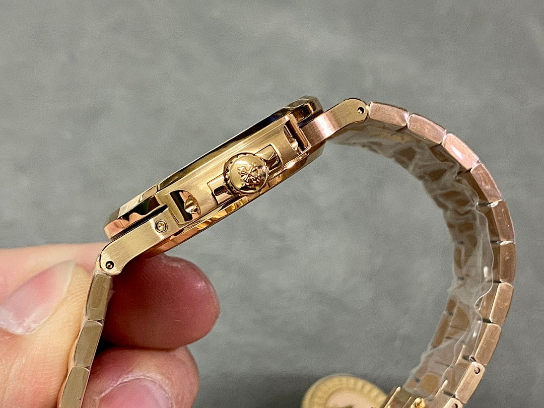 Gold-tone wristwatch clasp and crown side view, metal bracelet links