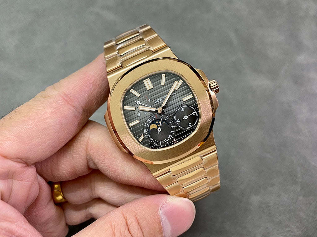 Gold-tone wristwatch with black dial and gold hour markers, held in hand
