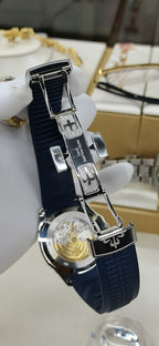 Patek Philippe watch side view with blue strap and jeweled bezel, crown detail.