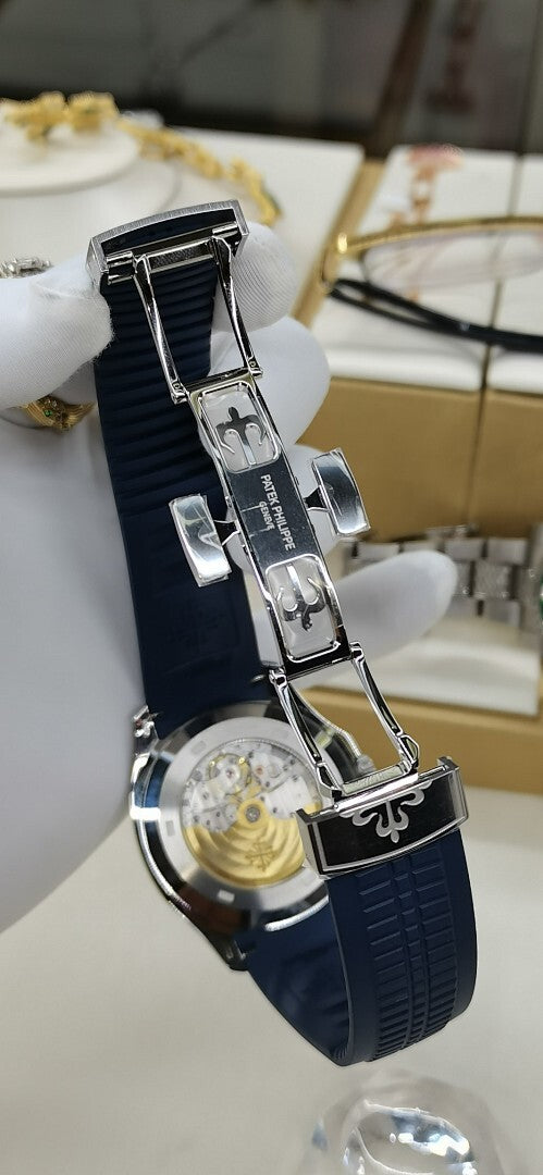 Patek Philippe watch side view with blue strap and jeweled bezel, crown detail.