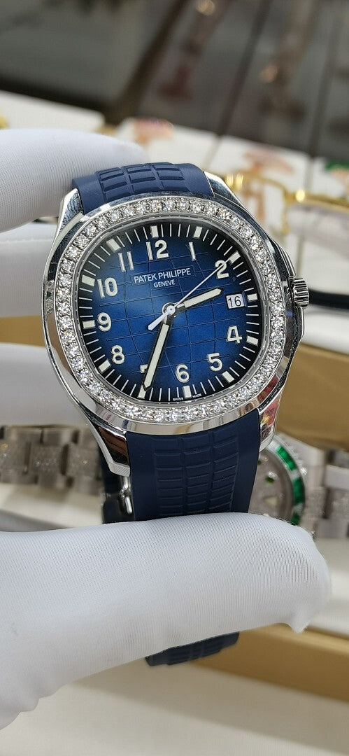 Patek Philippe watch front view with blue dial, diamond bezel, blue rubber strap.