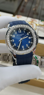 Patek Philippe watch front view with blue dial, diamond bezel, blue rubber strap.