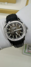 Patek Philippe wristwatch with black dial, diamond bezel, and black rubber strap