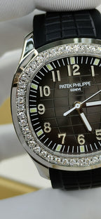 Patek Philippe watch close-up on black dial with diamond bezel and black rubber strap