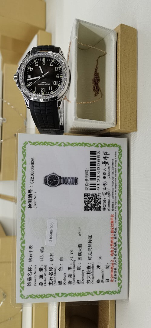 Patek Philippe watch with black rubber strap in box beside certificate card