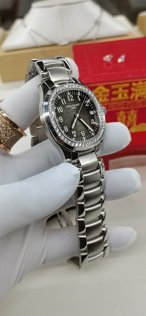 Luxury wristwatch with black dial, silver case, and diamond-studded bezel