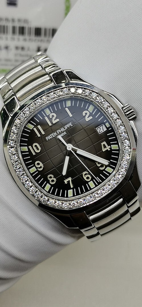 Luxury wristwatch close-up with black dial, silver diamond bezel, and metal bracelet links