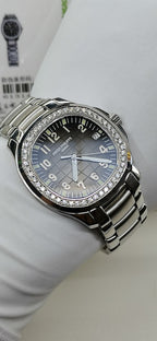 Luxury wristwatch with black dial, silver bezel with diamond accents, and metal bracelet
