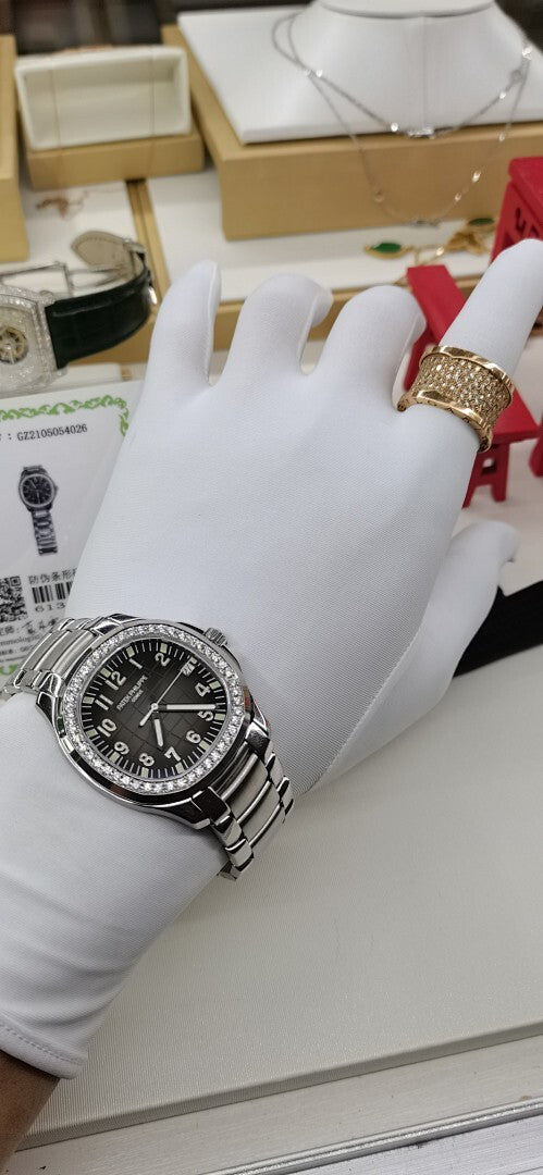 Luxury wristwatch on display with black dial and silver diamond bezel