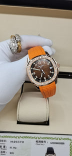 Patek Philippe watch with orange rubber strap and dark dial, diamond bezel, rose-gold case