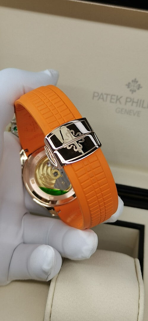 Patek Philippe watch with orange rubber strap and rose-gold clasp, visible dial window