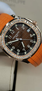 Patek Philippe watch with orange rubber strap, dark dial, diamond-set bezel and white hands