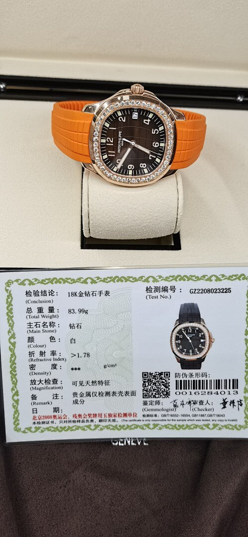 Patek Philippe watch on white display stand, orange rubber strap, dark dial, diamond bezel