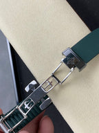 Green rubber watch strap with metal clasp and engraved details, silver links