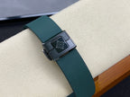Green rubber watch strap with square metal buckle featuring a dark emblem