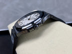 Patek Philippe watch side view with dark case and bracelet on a beige display