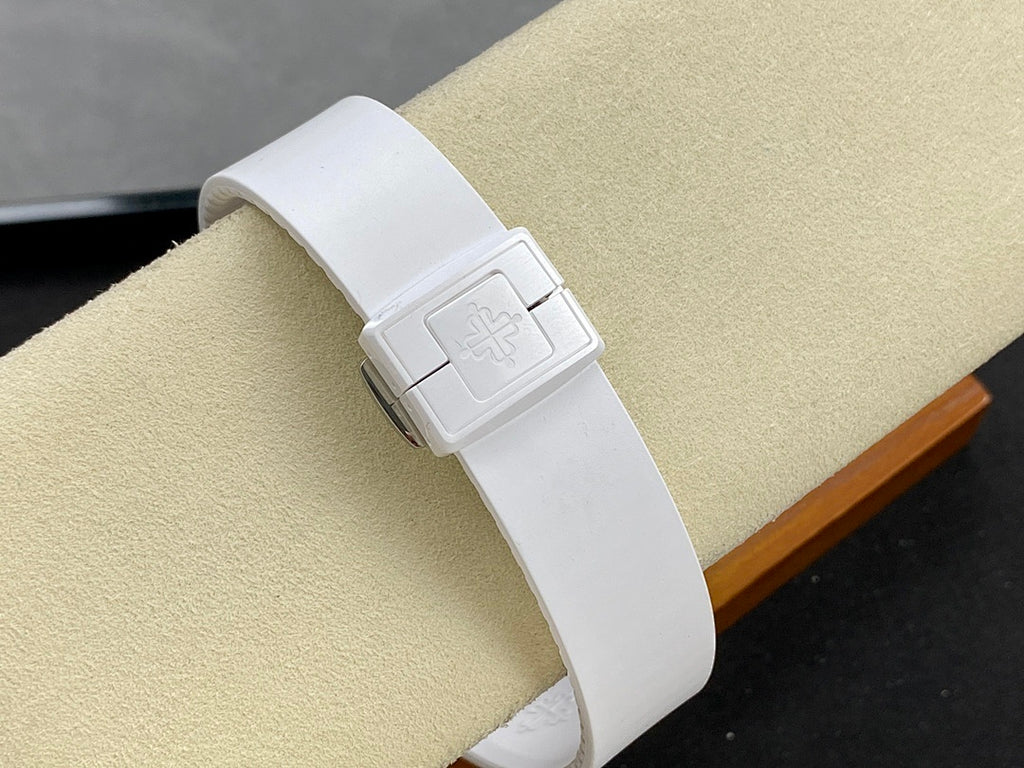 White wristwatch on a white strap with clasp and a stamped emblem on the strap.