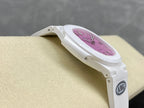 White wristwatch side view with pink dial and round bezel.