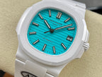 White wristwatch with turquoise dial, baton markers, and date window at 3 o'clock