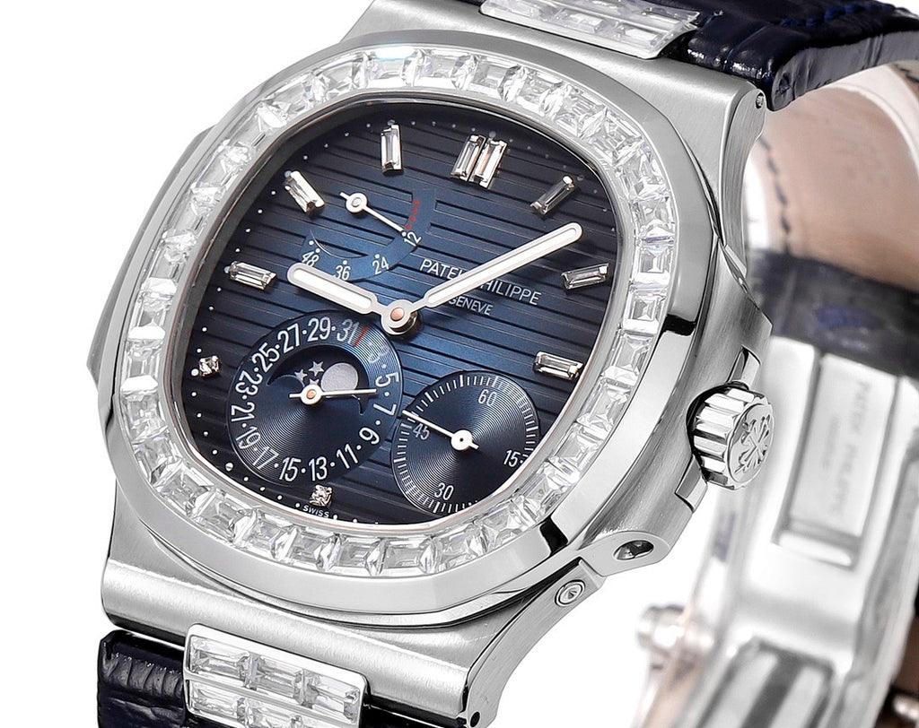 Wristwatch dial close-up with blue subdials, silver markers, and gem-set bezel