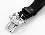Patek Philippe watch with black leather strap and silver clasp, side view.