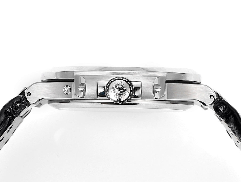 Patek Philippe watch case top with engraved emblem and polished bezel, side view.