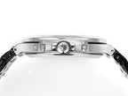 Patek Philippe watch case top with engraved emblem and polished bezel, side view.