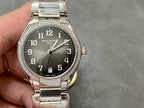 Patek Philippe steel watch with diamond bezel, dark dial and date window