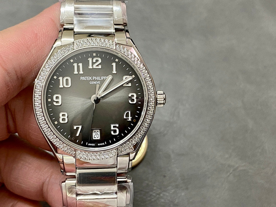 Patek Philippe steel watch with diamond bezel, dark dial and date window