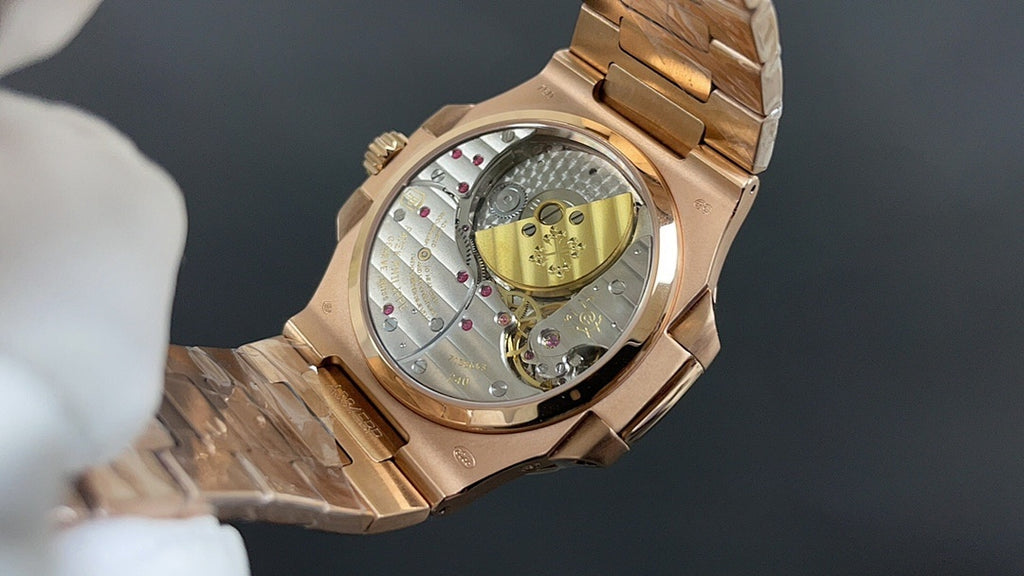 Patek Philippe watch case with see-through back, gold-tone links and rotor