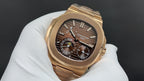 Patek Philippe watch with dark dial, gold markers, moonphase subdial, gold-tone bracelet