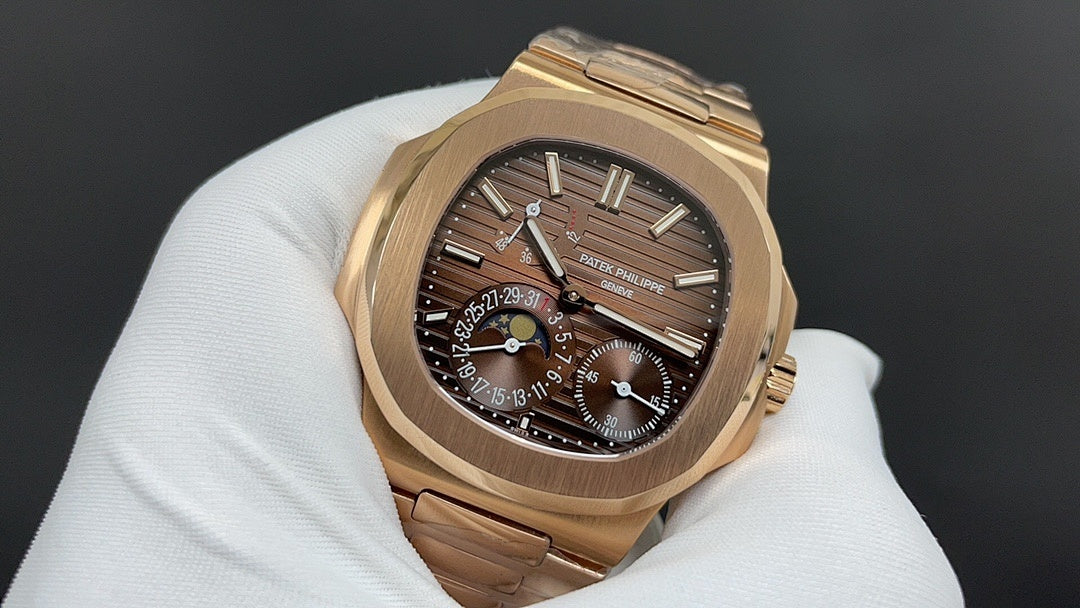 Patek Philippe watch with dark dial, gold markers, moonphase subdial, gold-tone bracelet
