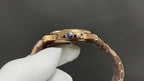 Patek Philippe rose gold wristwatch side with crown guard and blue gemstone