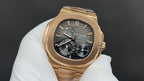 Patek Philippe rose gold wristwatch with black dial and date window