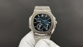 Patek Philippe watch with silver bracelet and dark blue dial, multiple subdials.