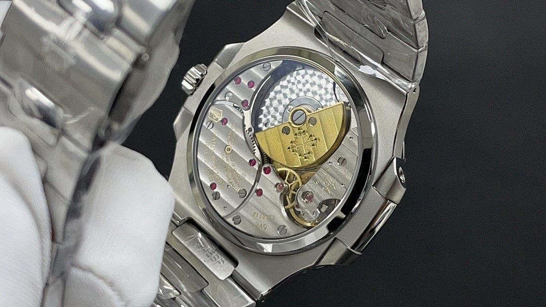 Patek Philippe watch caseback with exposed mechanical movement and gold plate.