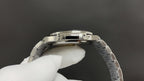 Patek Philippe watch side view with silver case and textured bezel teeth.