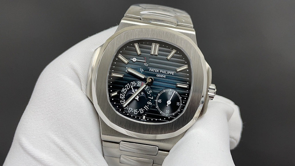 Patek Philippe watch with dark blue dial and silver bezel, visible subdials.
