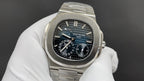 Patek Philippe watch with dark blue dial and silver bezel, visible subdials.