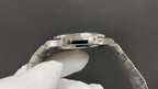 Stainless steel watch caseback with detailed rim, worn on metal link bracelet