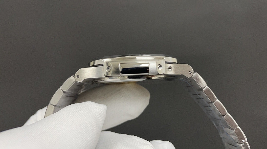 Stainless steel watch caseback with detailed rim, worn on metal link bracelet