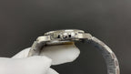 Stainless steel watch case with exposed movement components, clear window at top