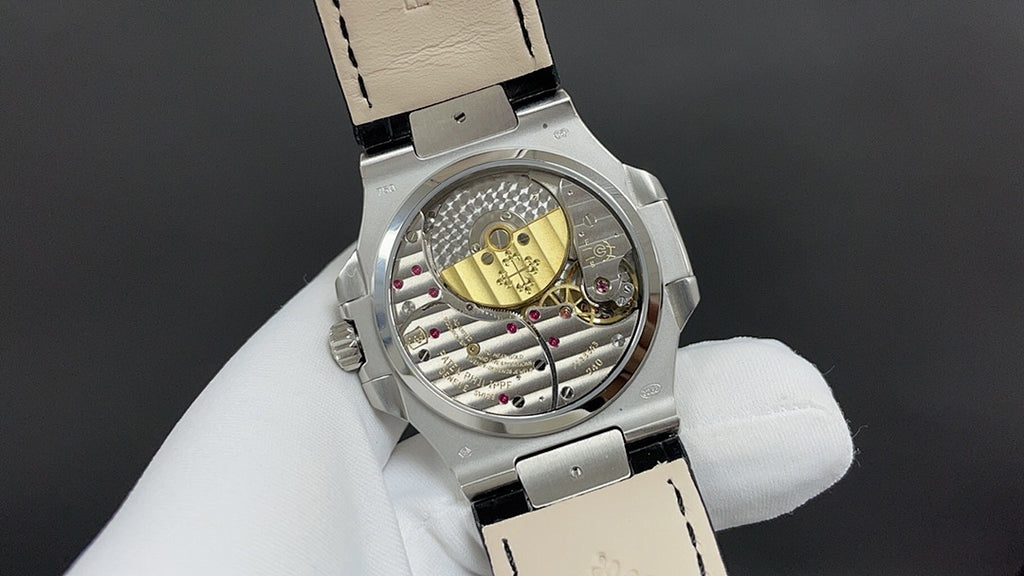 Patek Philippe watch, open caseback showing movement, steel and black leather strap